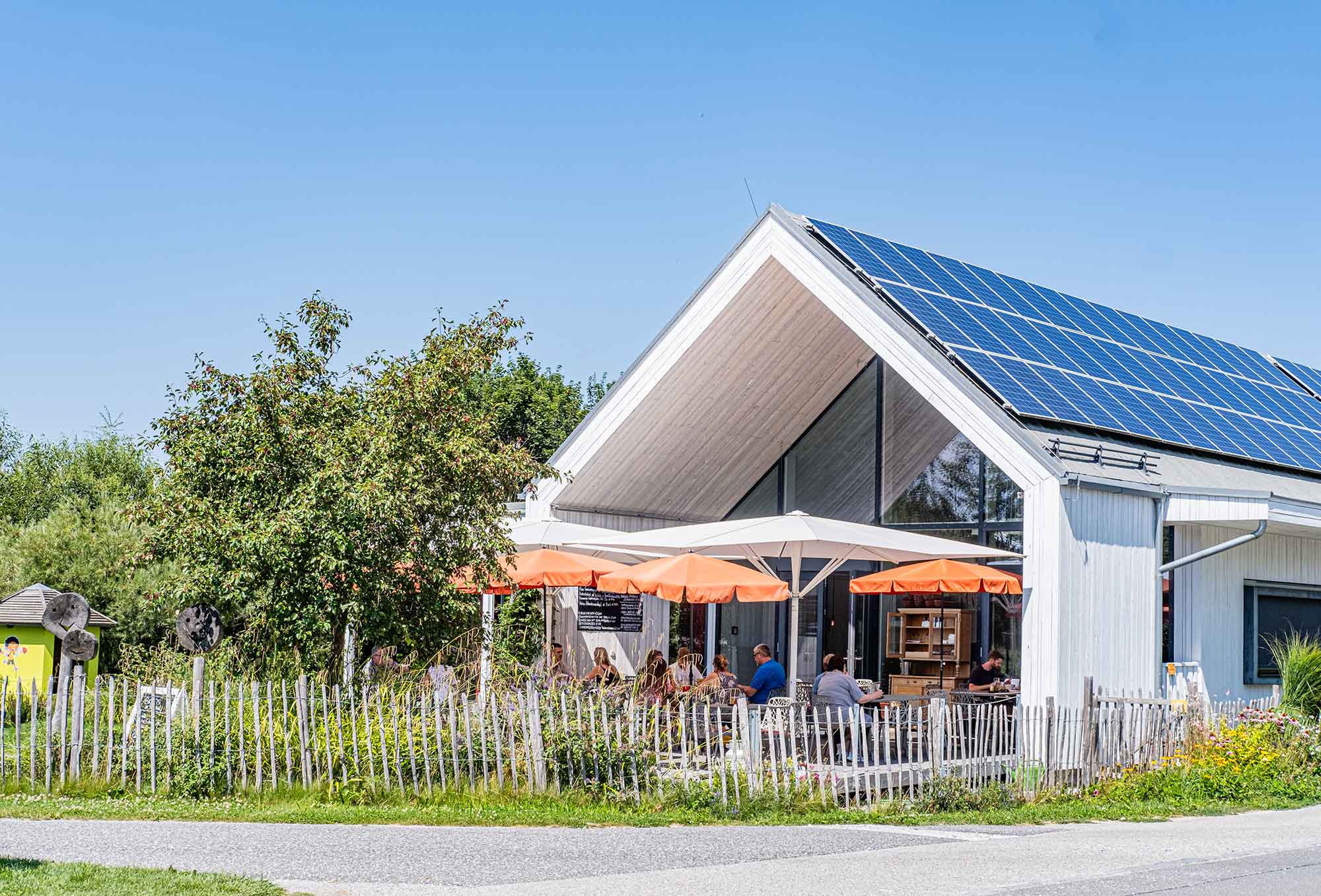 Außenansicht des Biogasthauses Leibspeis mit Sonnenterrasse und Solarpanelen