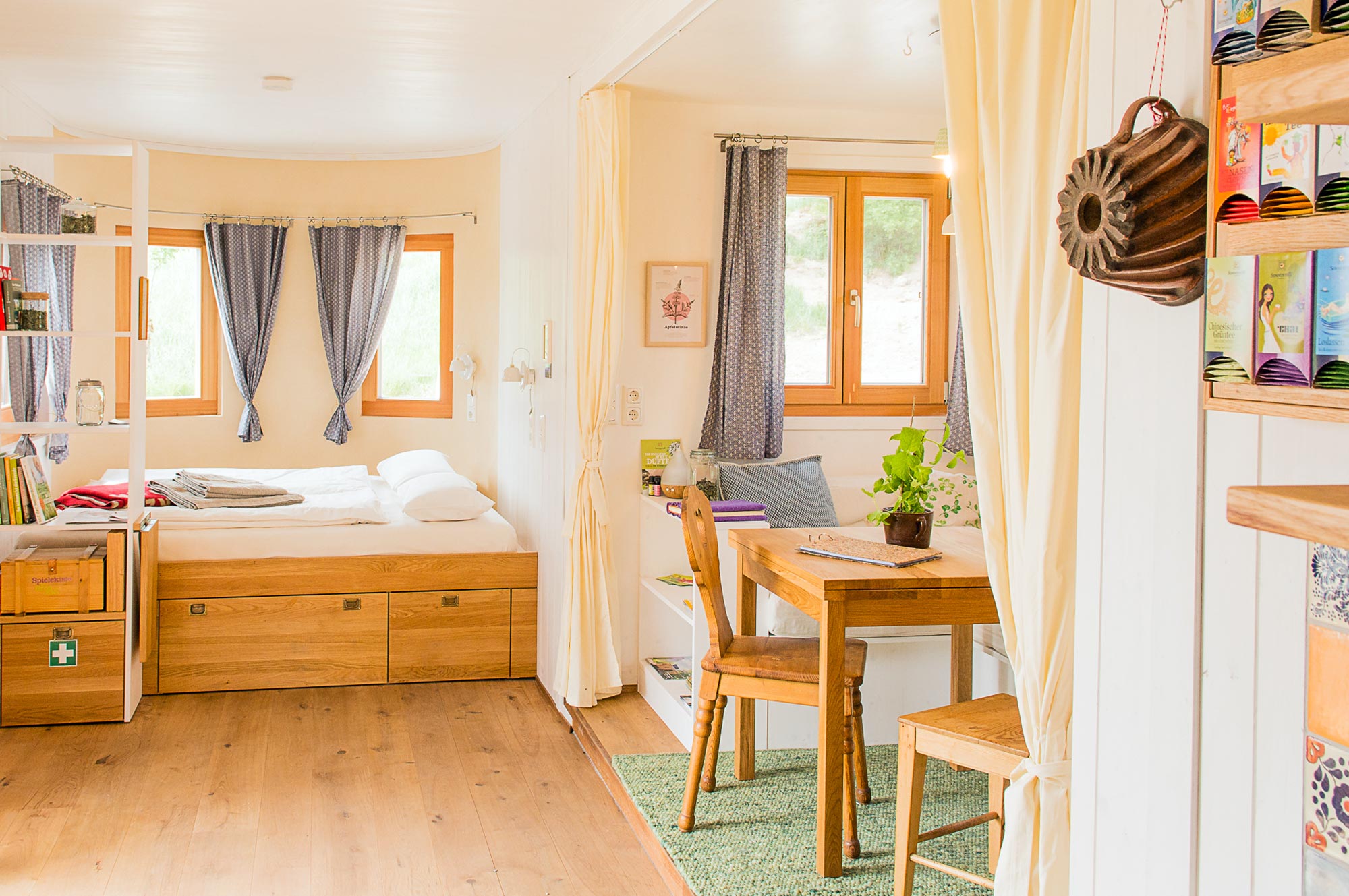 Gemütlicher Innenraum eines Land Lofts mit Holzbett, Schreibtisch und Naturmaterialien