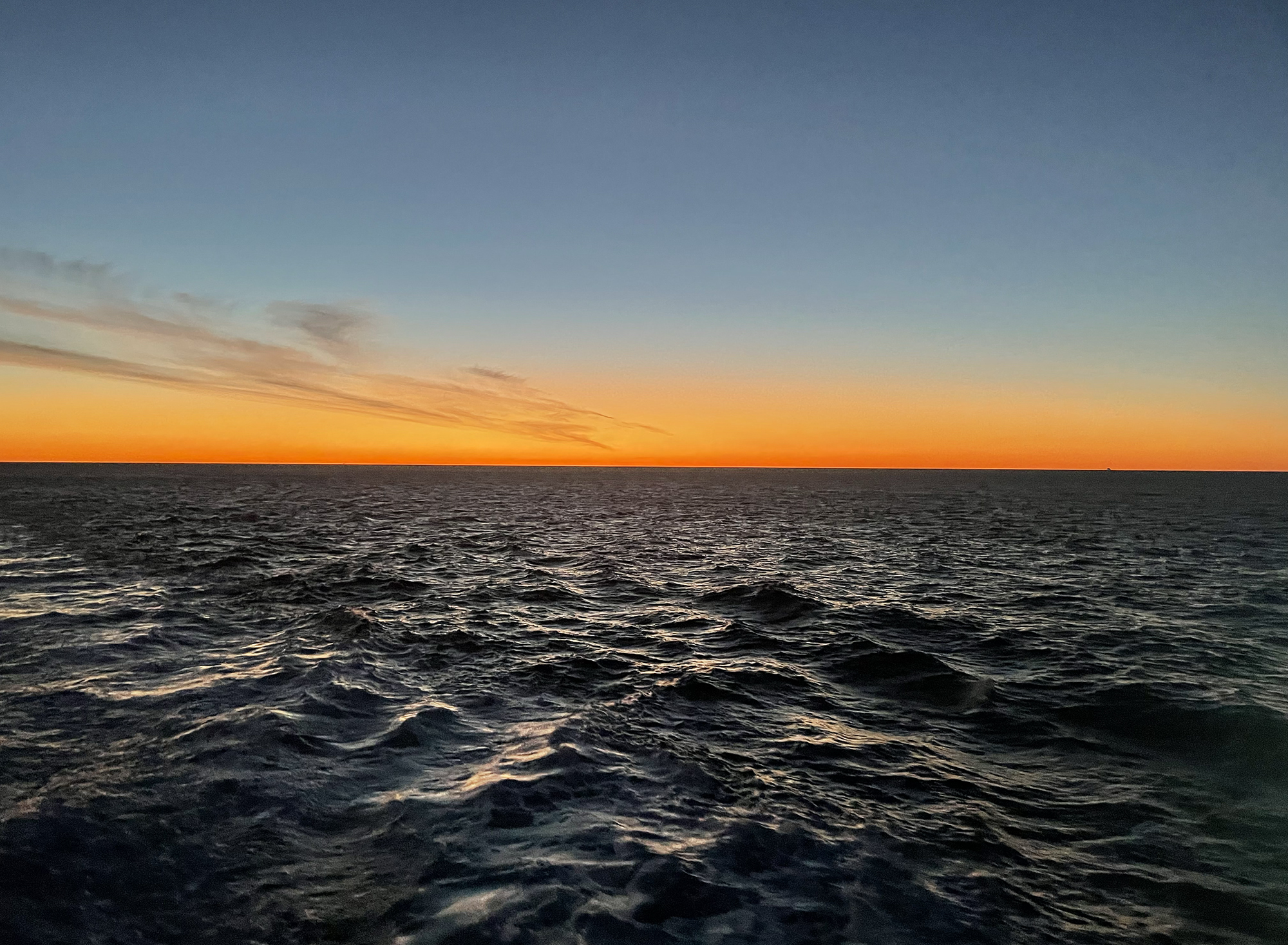 Tiefes Orange am Horizont über dem dunklen Atlantik, aufgenommen vom Deck der Fähre auf dem Weg nach Cádiz