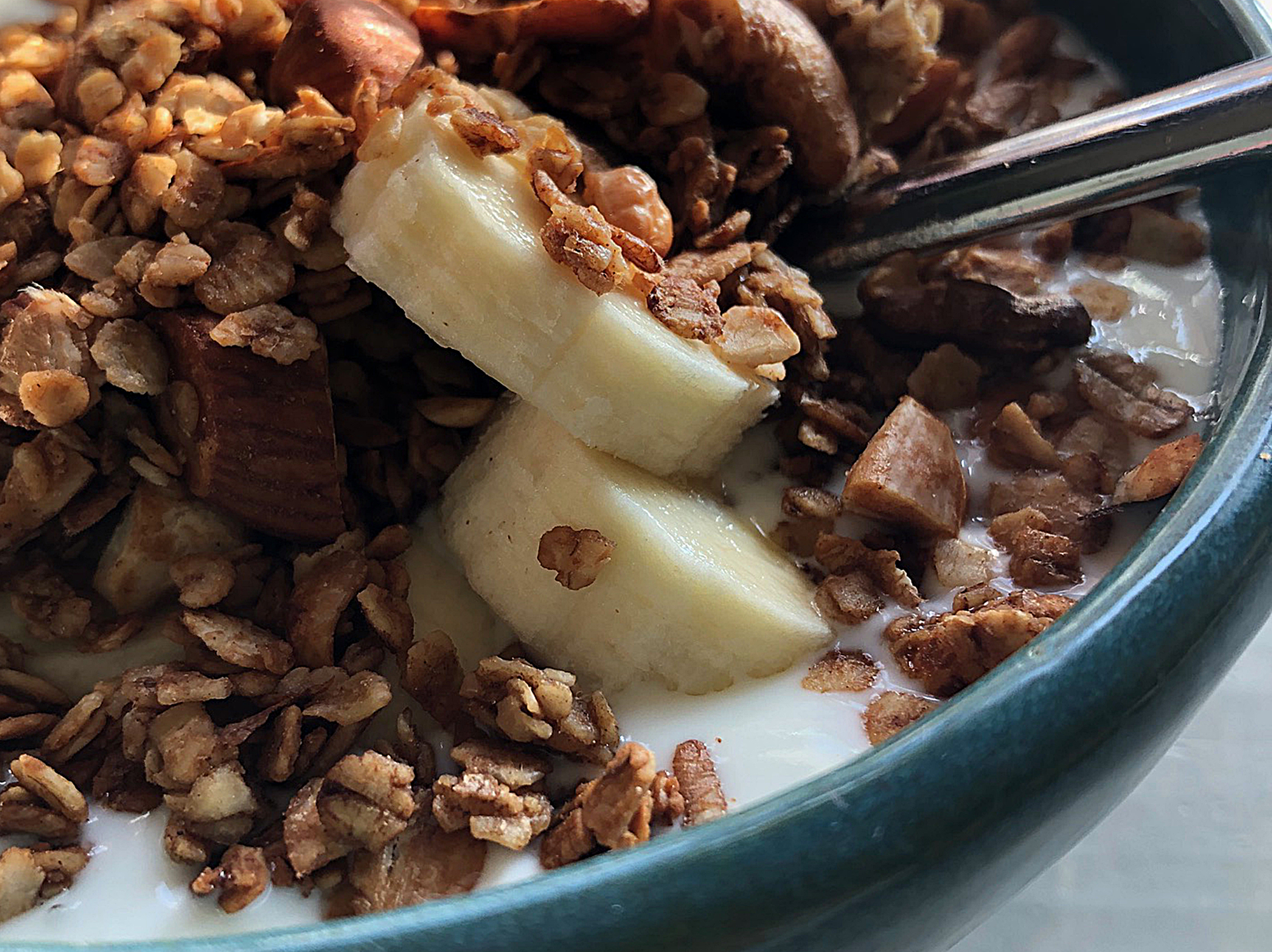 Müslischüssel mit hausgemachtem Granola, Joghurt, Bananenscheiben und ganzen Nüssen – Frühstück im B&B De Brenschutte, Niederlande