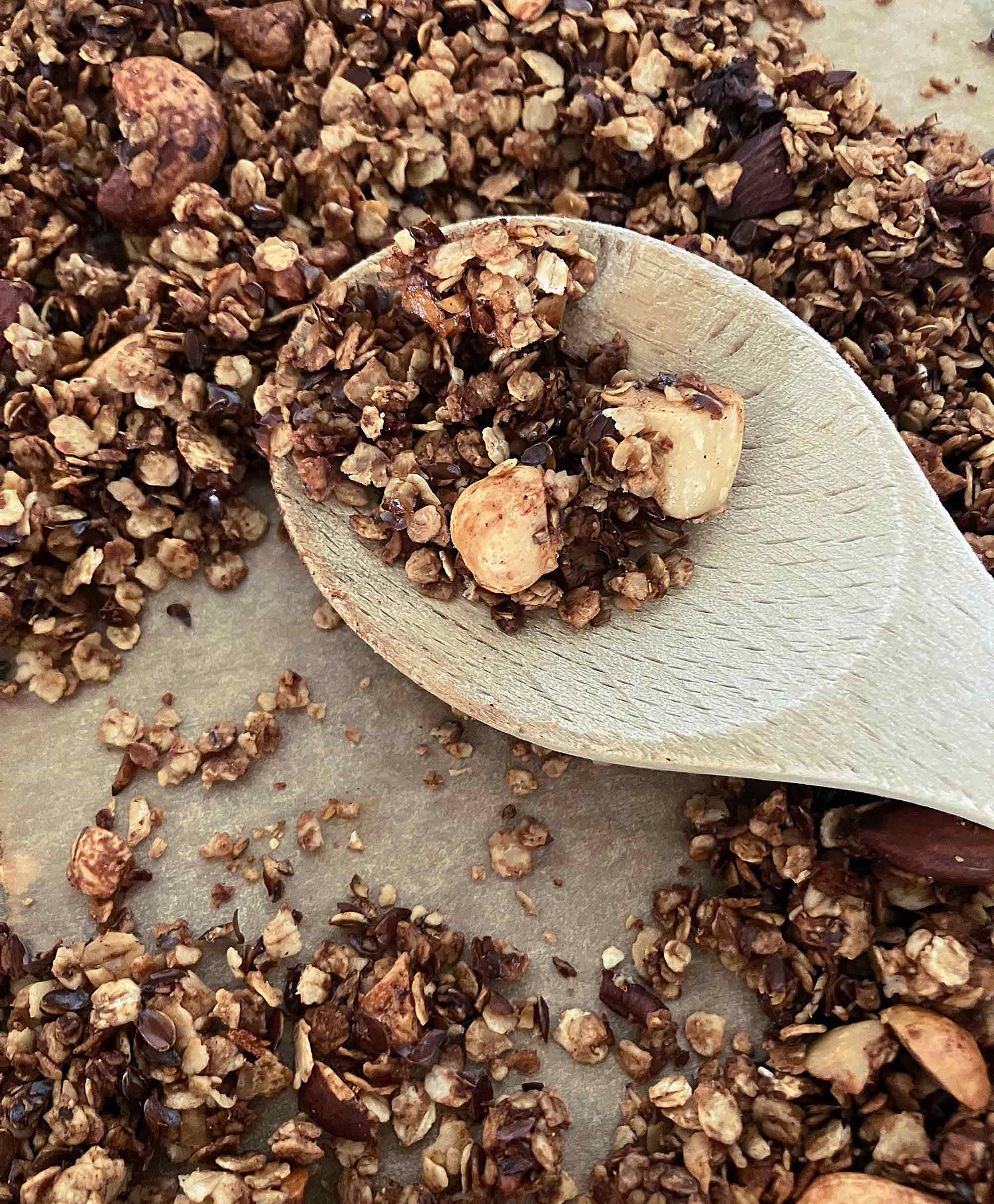 Selbstgemachtes Granola mit Haferflocken, Nüssen und Schokolade auf einem Holzlöffel – Frühstück im B&B De Brenschutte, Niederlande
