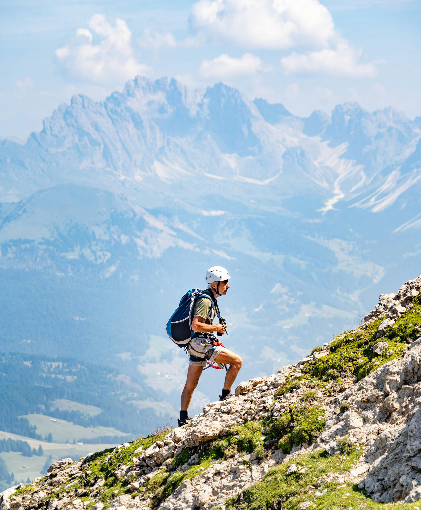 Bergsteiger mit Helm und Rucksack auf felsigem Grat in den Alpen – Good Travel Blog