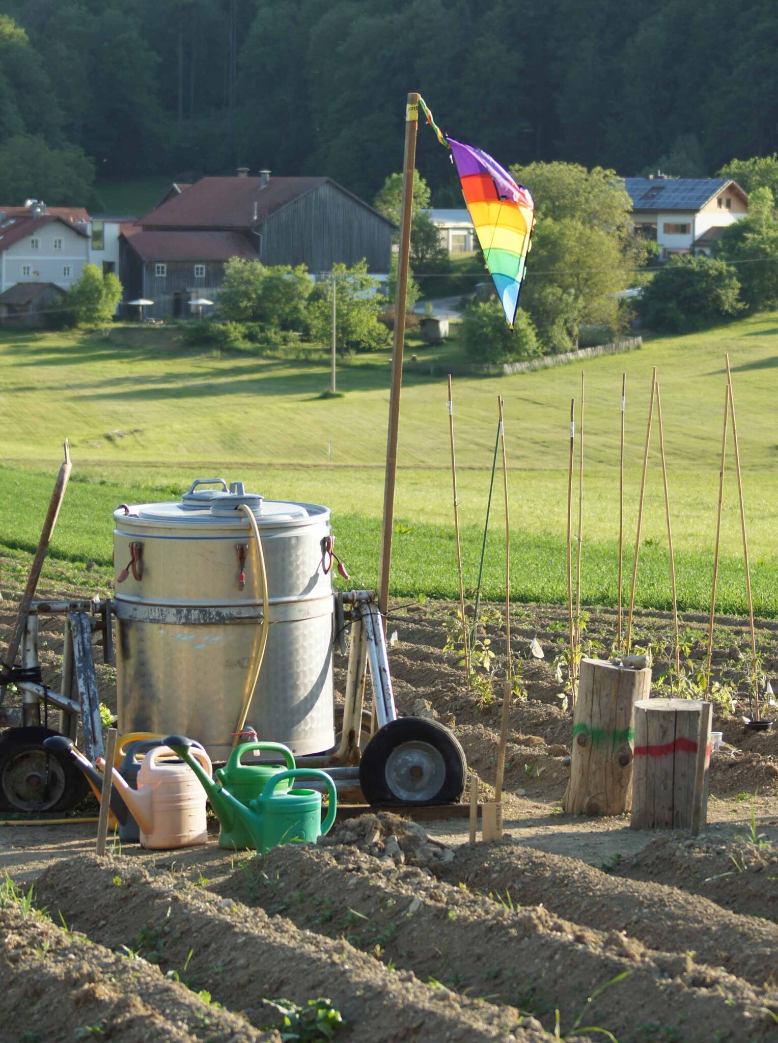 Gemüsegarten am Hof Moosham13 in Grafenau mit Regentonnen und Hügellandschaft des Bayerischen Waldes im Hintergrund
