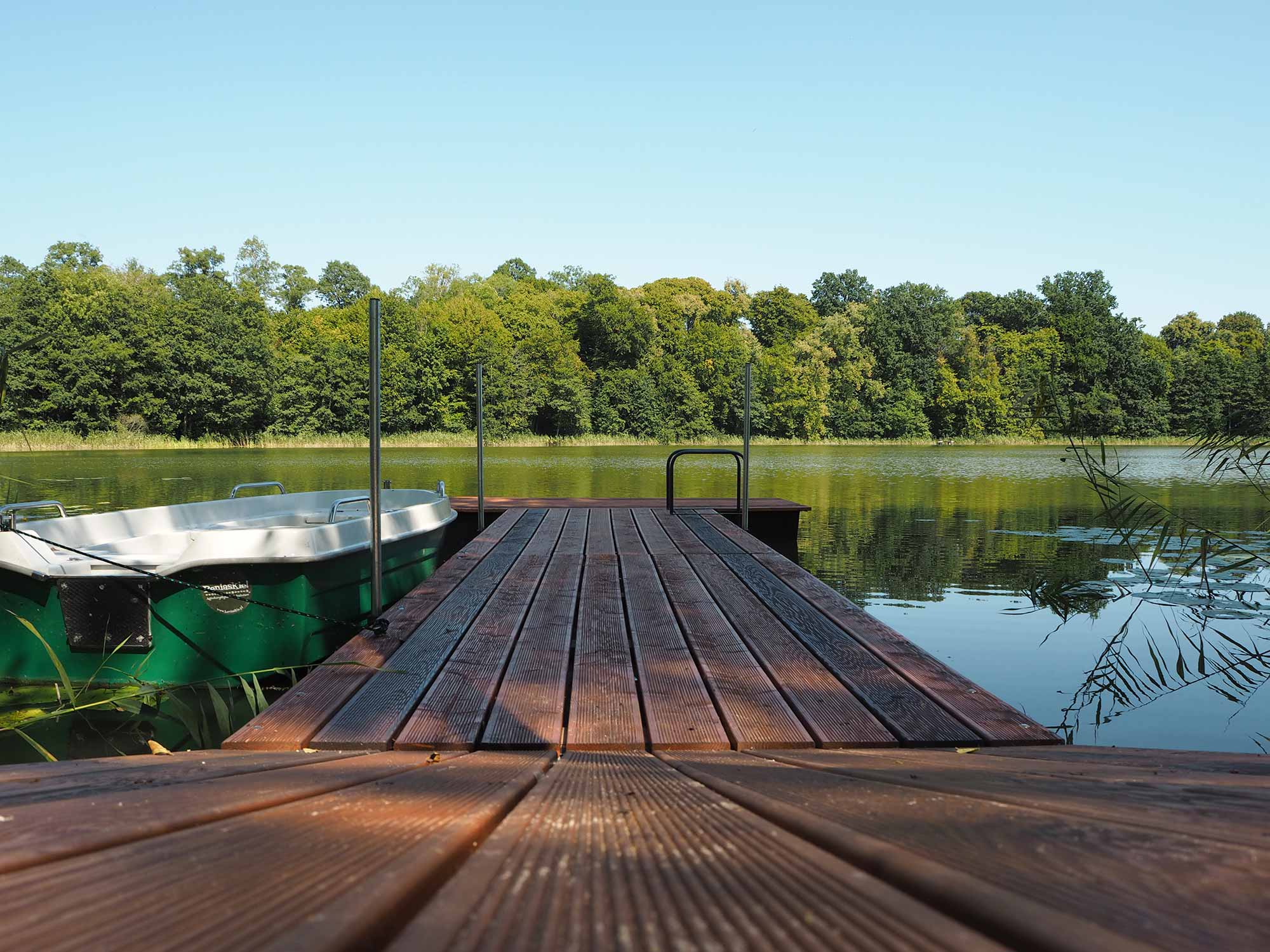 Holzsteg mit Ruderboot am See beim Agriturismo Beniaskie!, Bieniasze, Ermland-Masuren, Polen