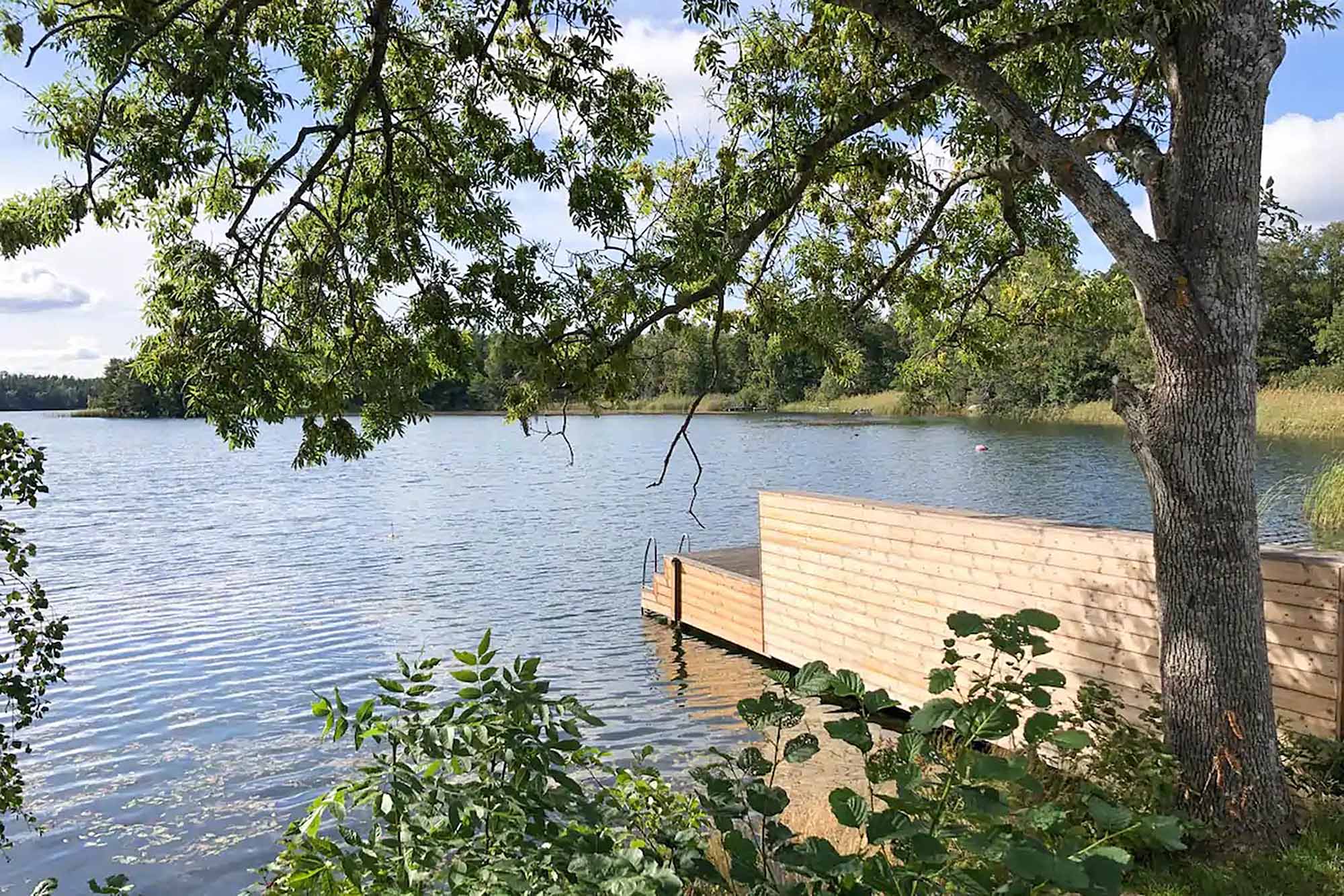 Holzsteg mit Einstiegsleiter am See beim Ferienhaus Goda in Skälvik, Schweden