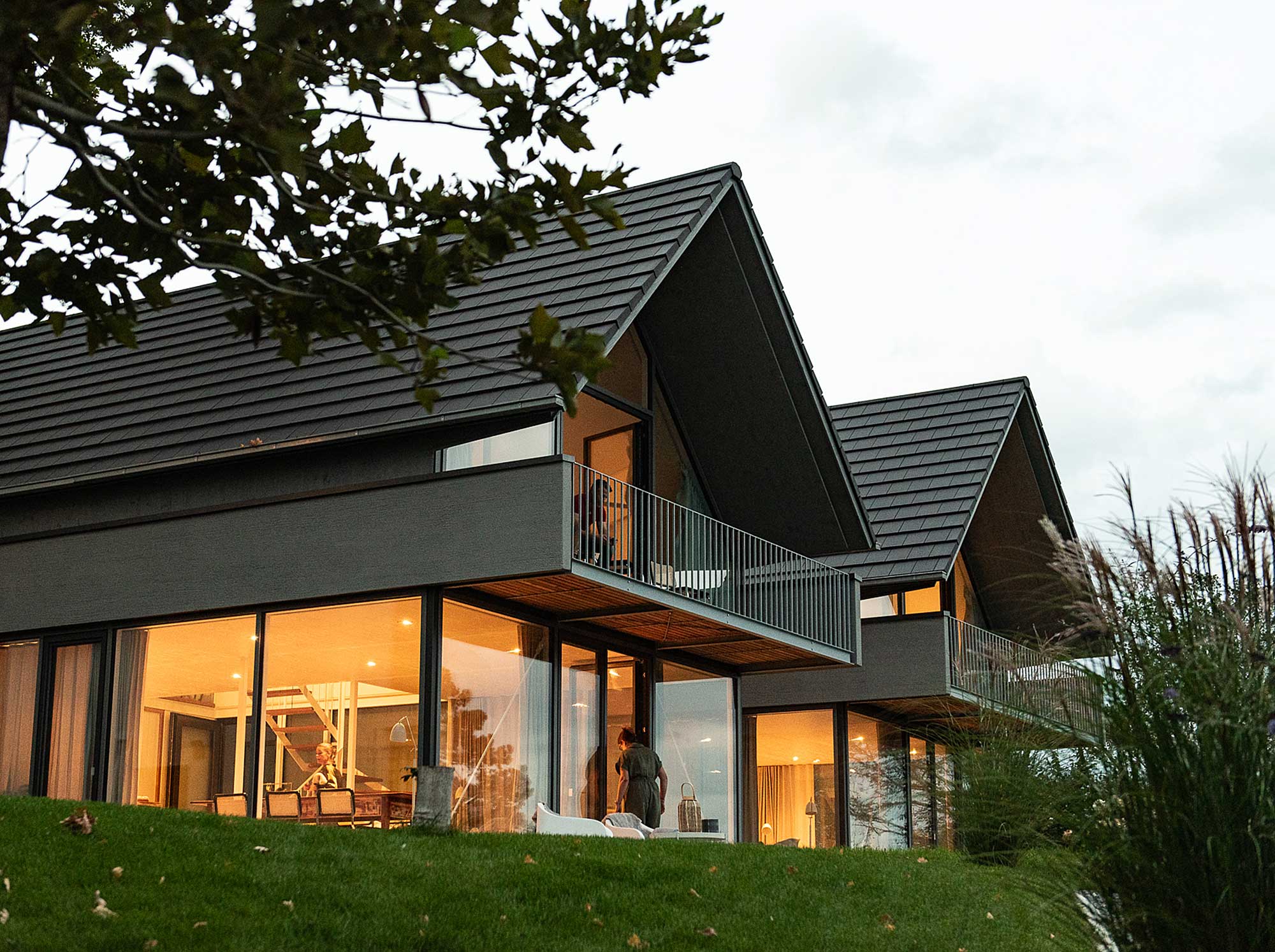 Außenansicht des Ferienhauses hermann&mia mit Giebeldach und beleuchteten Fenstern in Gaienhofen am Bodensee