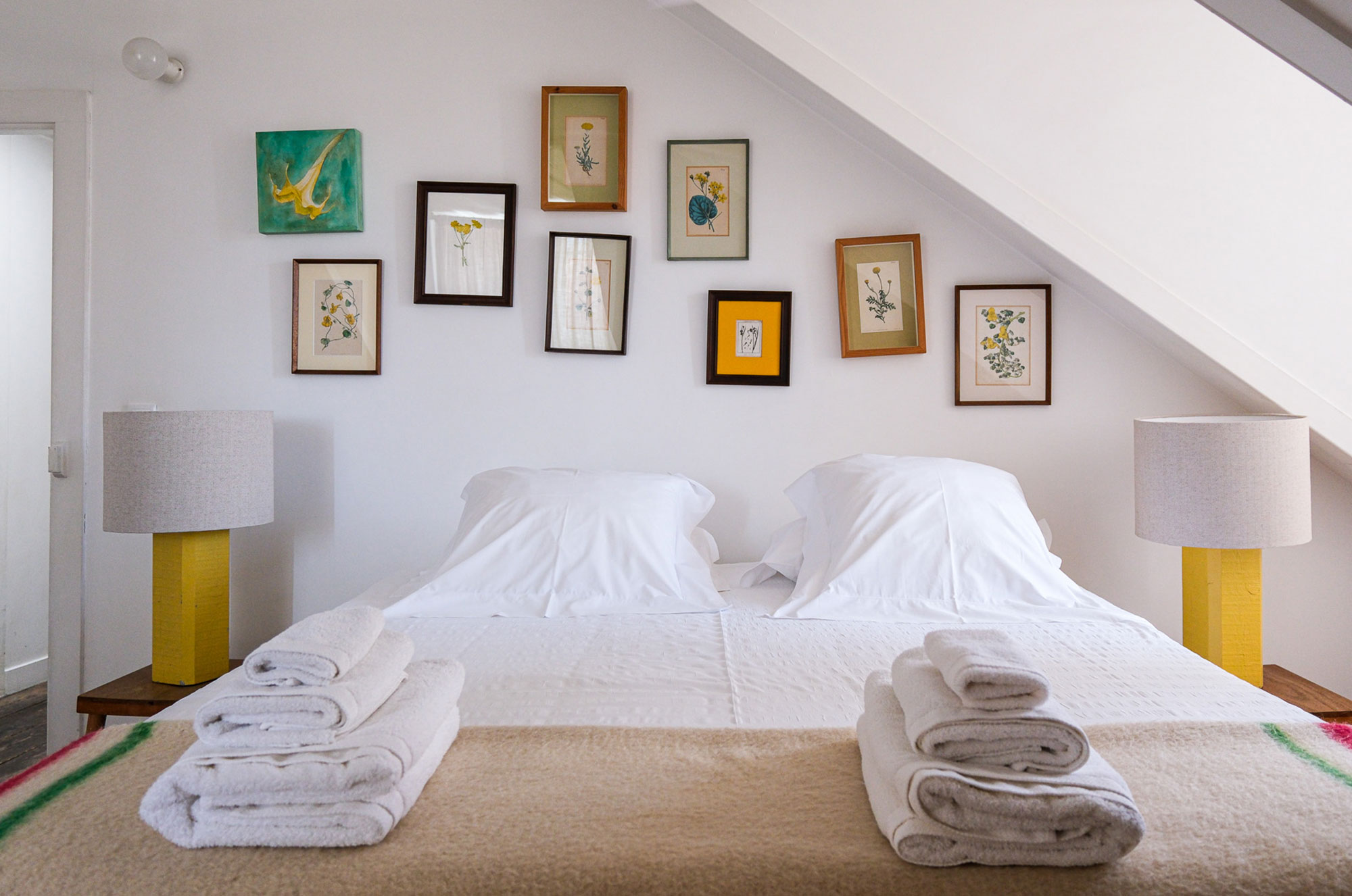 Schlafzimmer mit botanischer Bildergalerie und frischen Handtüchern im Baixa House, Lissabon