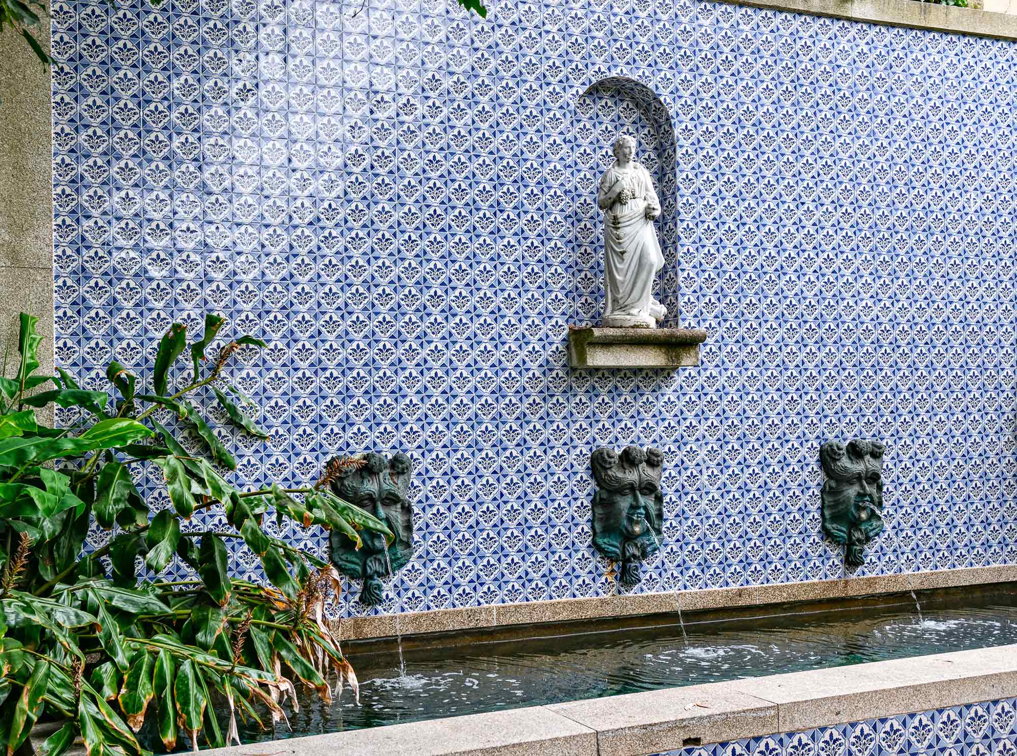 Blau-weiße Azulejo-Fliesenwand mit Brunnen und Heiligenfigur im Innenhof des Massarelos House in Porto