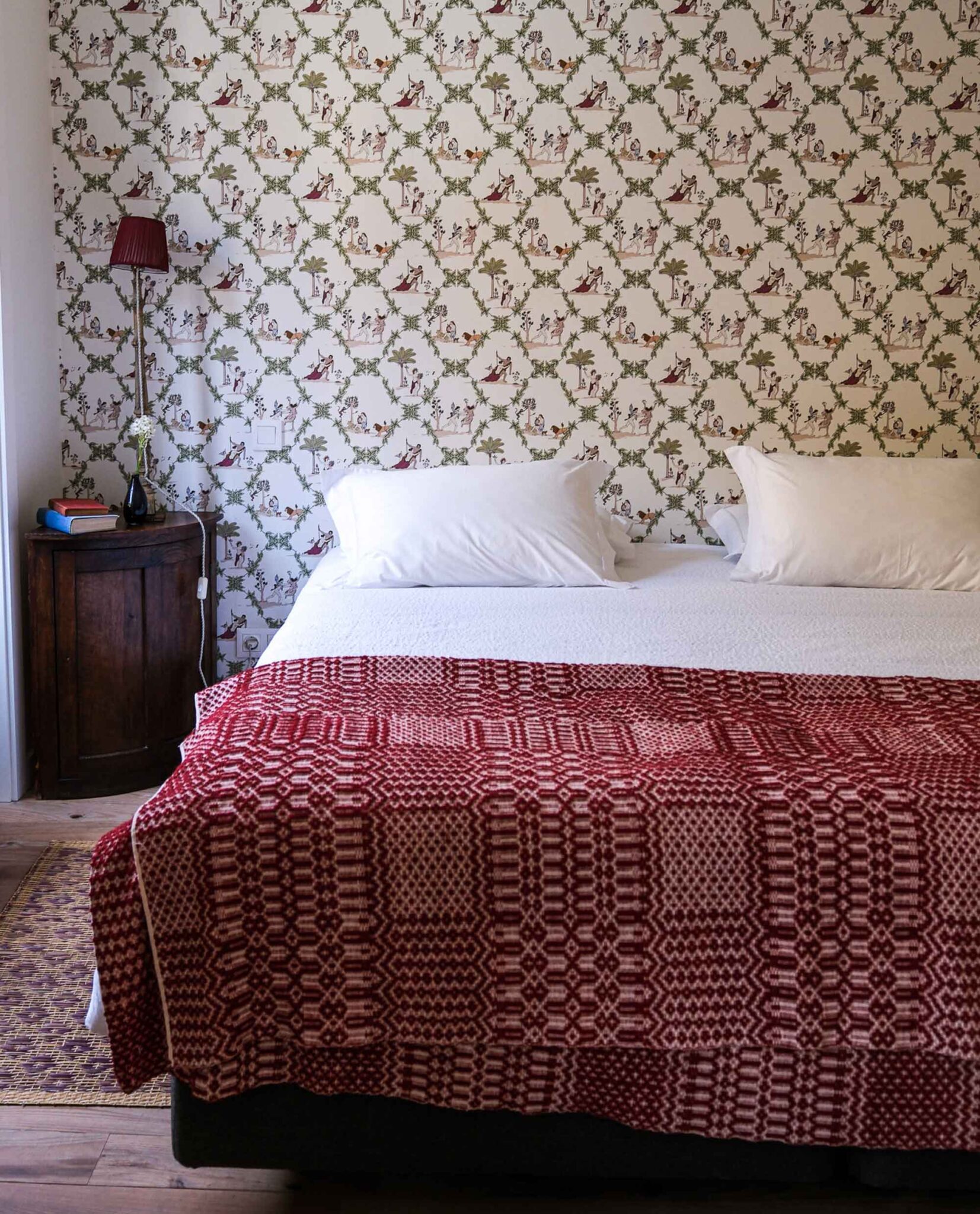 Schlafzimmer mit gemustertem Wandbild und rot-weißer Tagesdecke im Massarelos House, Porto