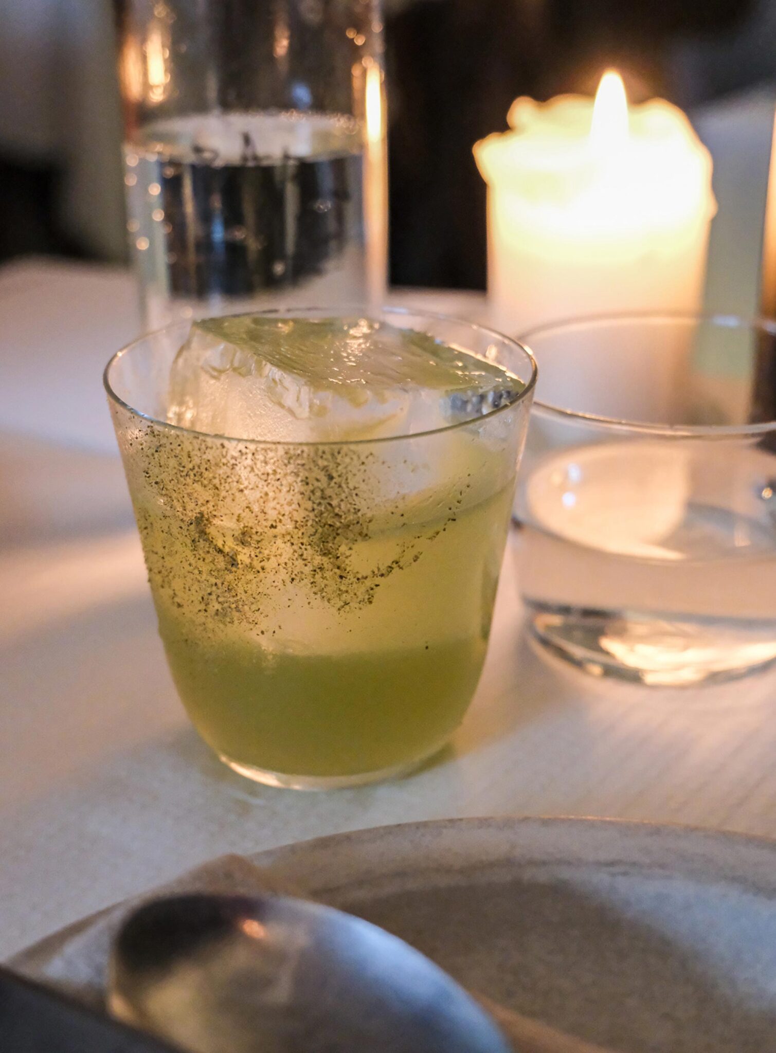Grüner Cocktail bei Kerzenlicht in der Bar Alimentar in Lissabon