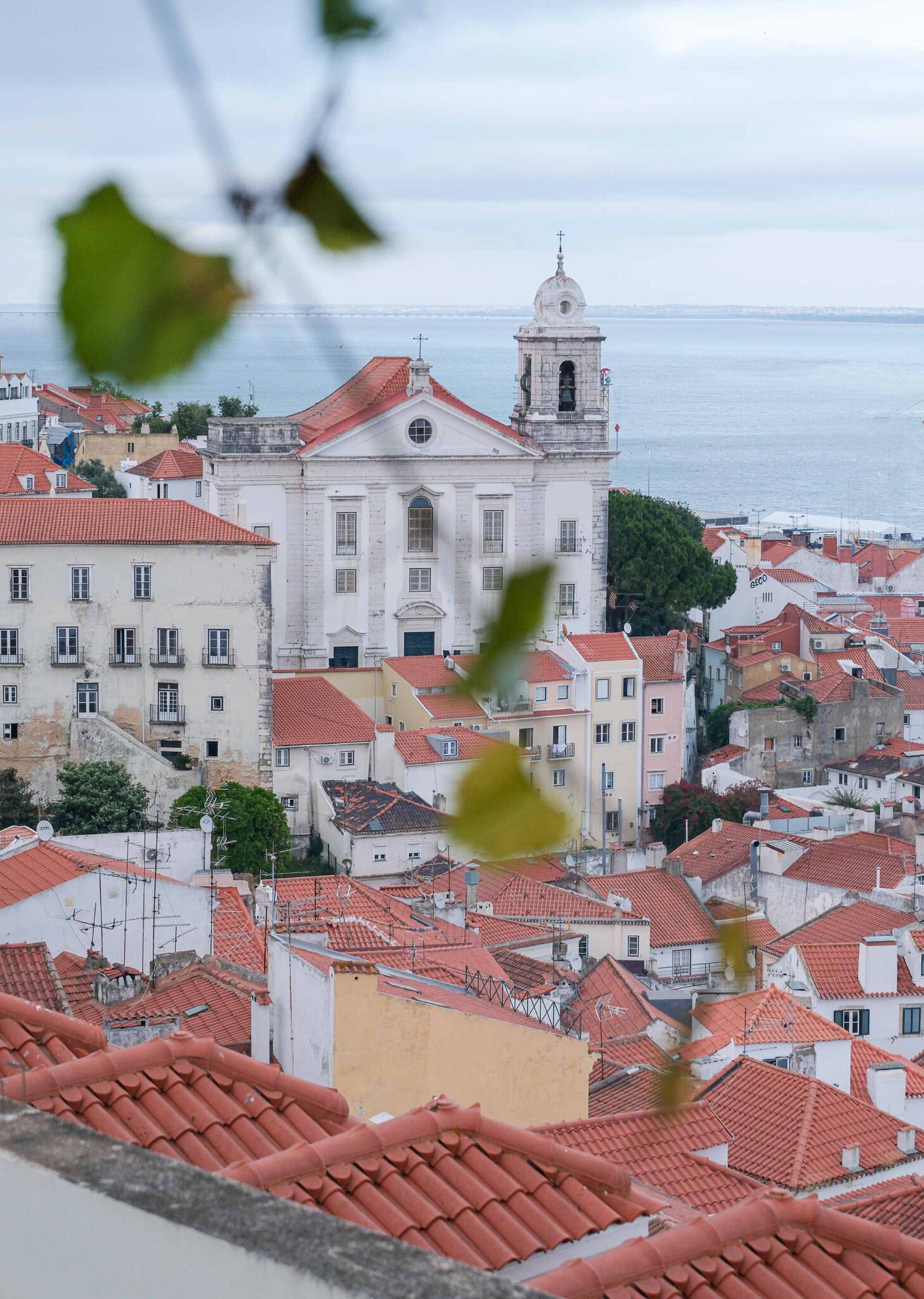 Blick über die roten Dächer von Alfama auf den Tejo in Lissabon