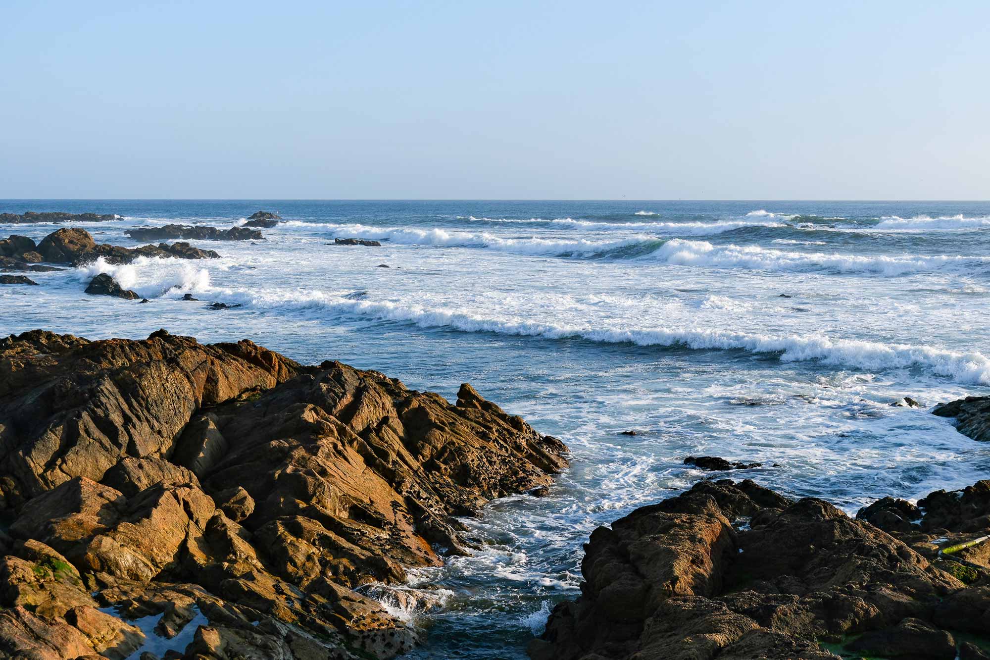 Wellen brechen an den rauen Granitfelsen der Atlantikküste bei Porto