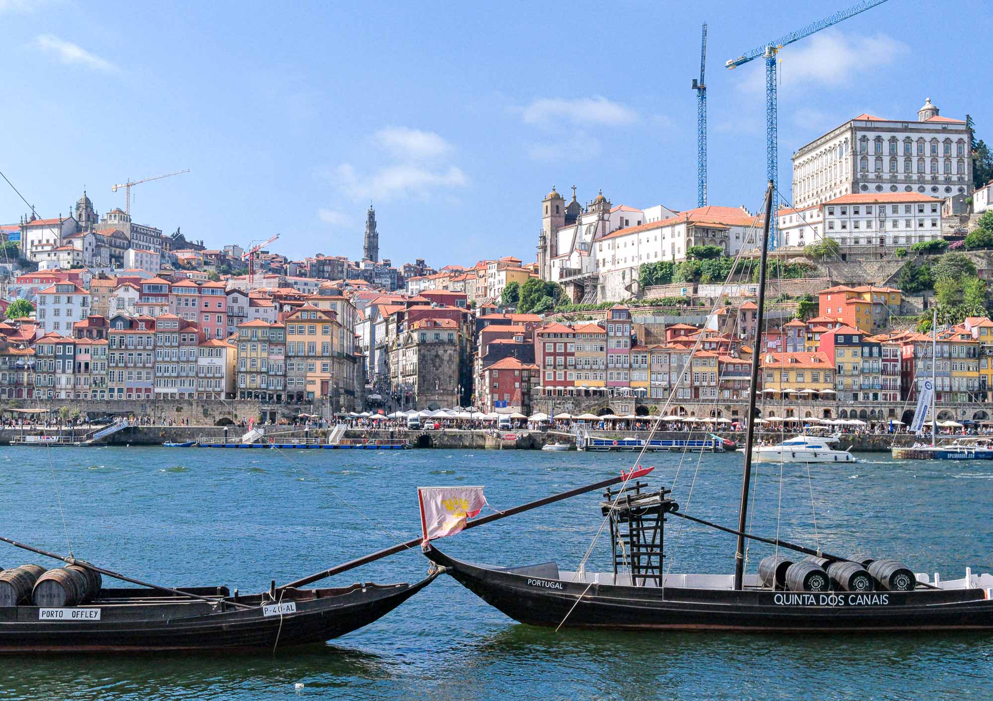 Blick über den Douro auf die bunte Altstadt-Skyline von Porto mit Rabelo-Booten