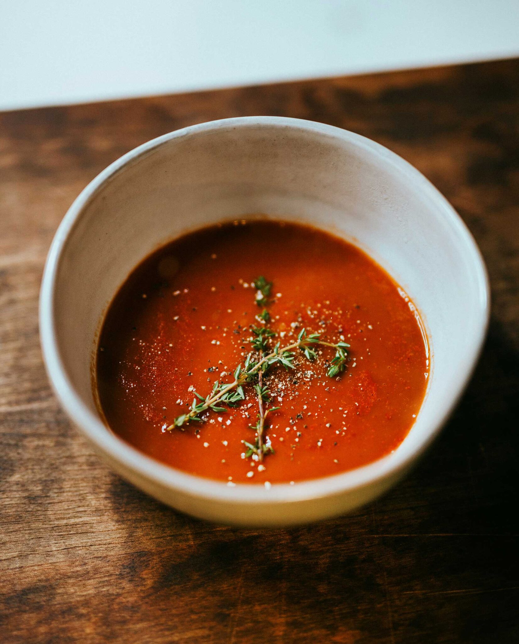 Kalte Gazpacho-Suppe aus Tomaten mit frischem Thymian in rustikaler Schale