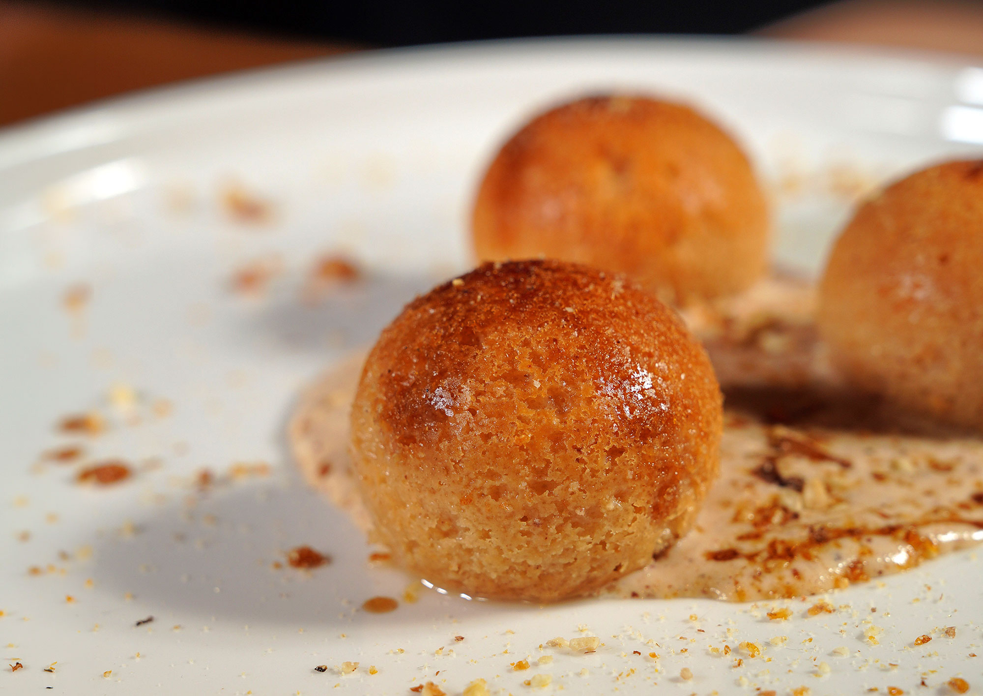 Goldbraun gebratene Marillenknödel in Butterbröseln auf dem Teller