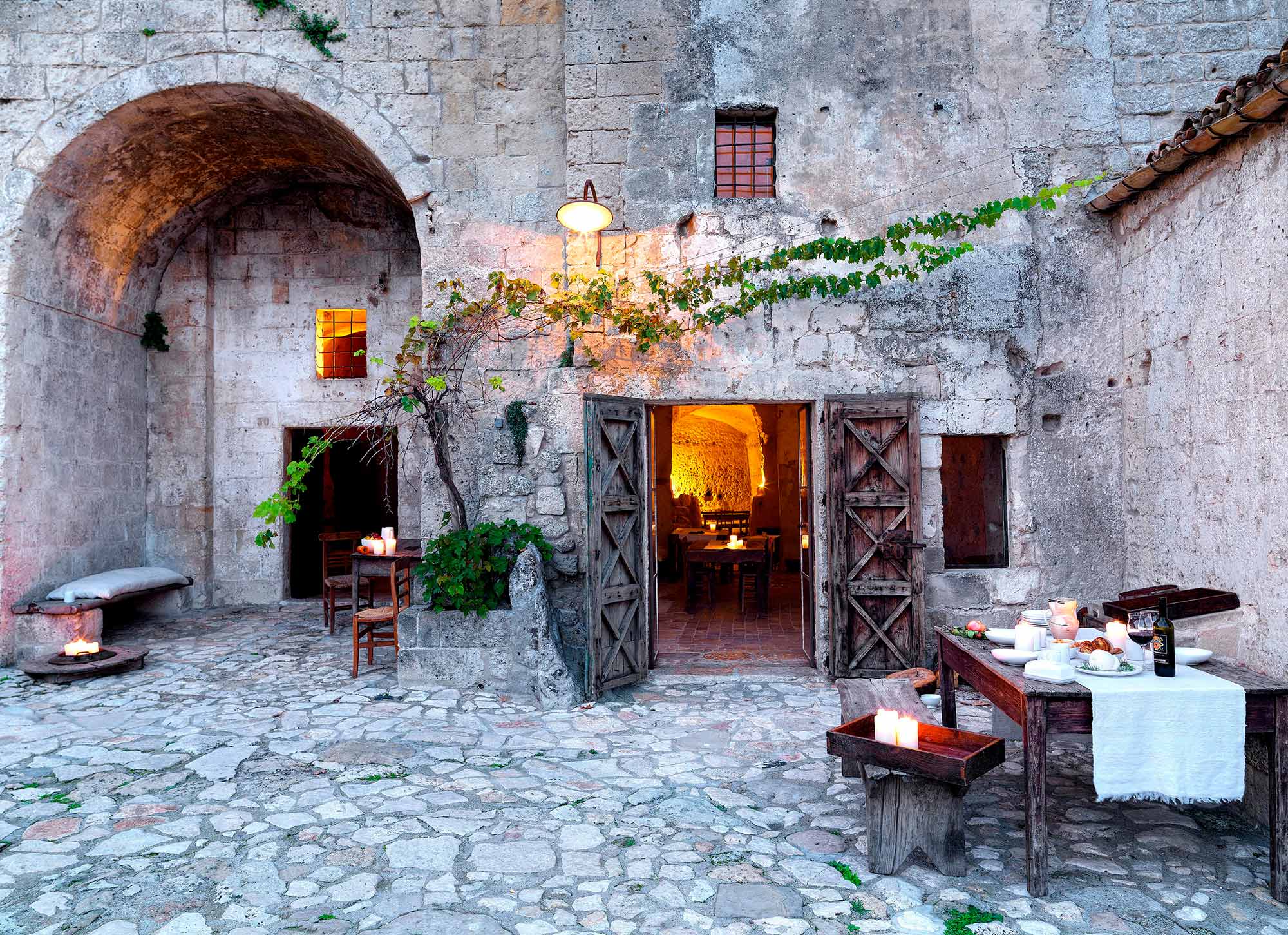 Candlelight gedeckter Tisch im Innenhof eines Albergo Diffuso in den Höhlenwohnungen von Matera