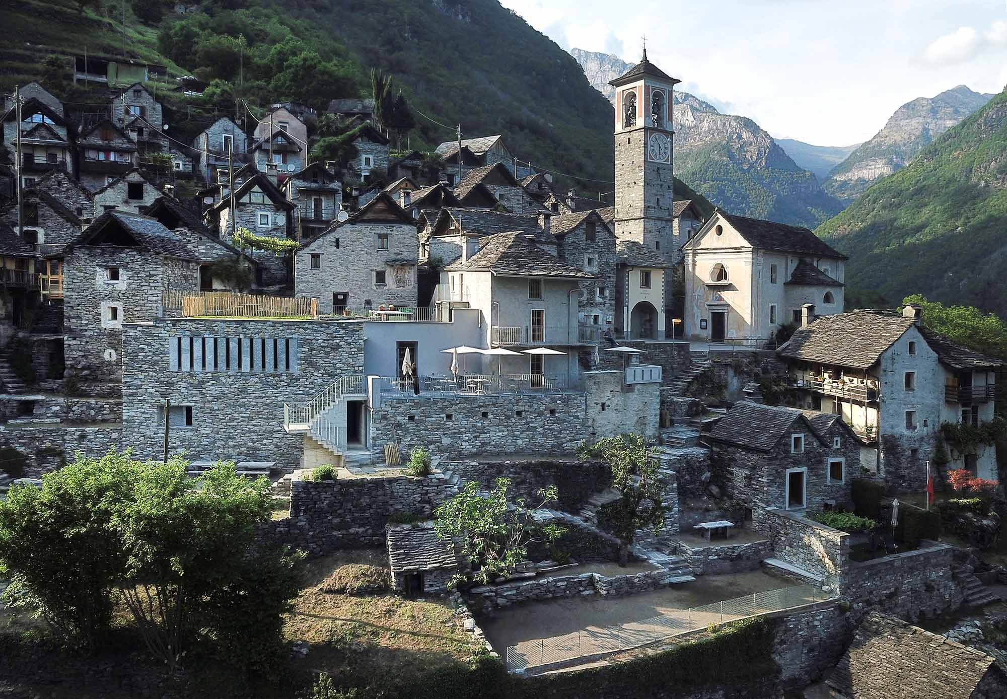 Luftaufnahme eines historischen Bergdorfs mit Kirchturm im Schweizer Tessin