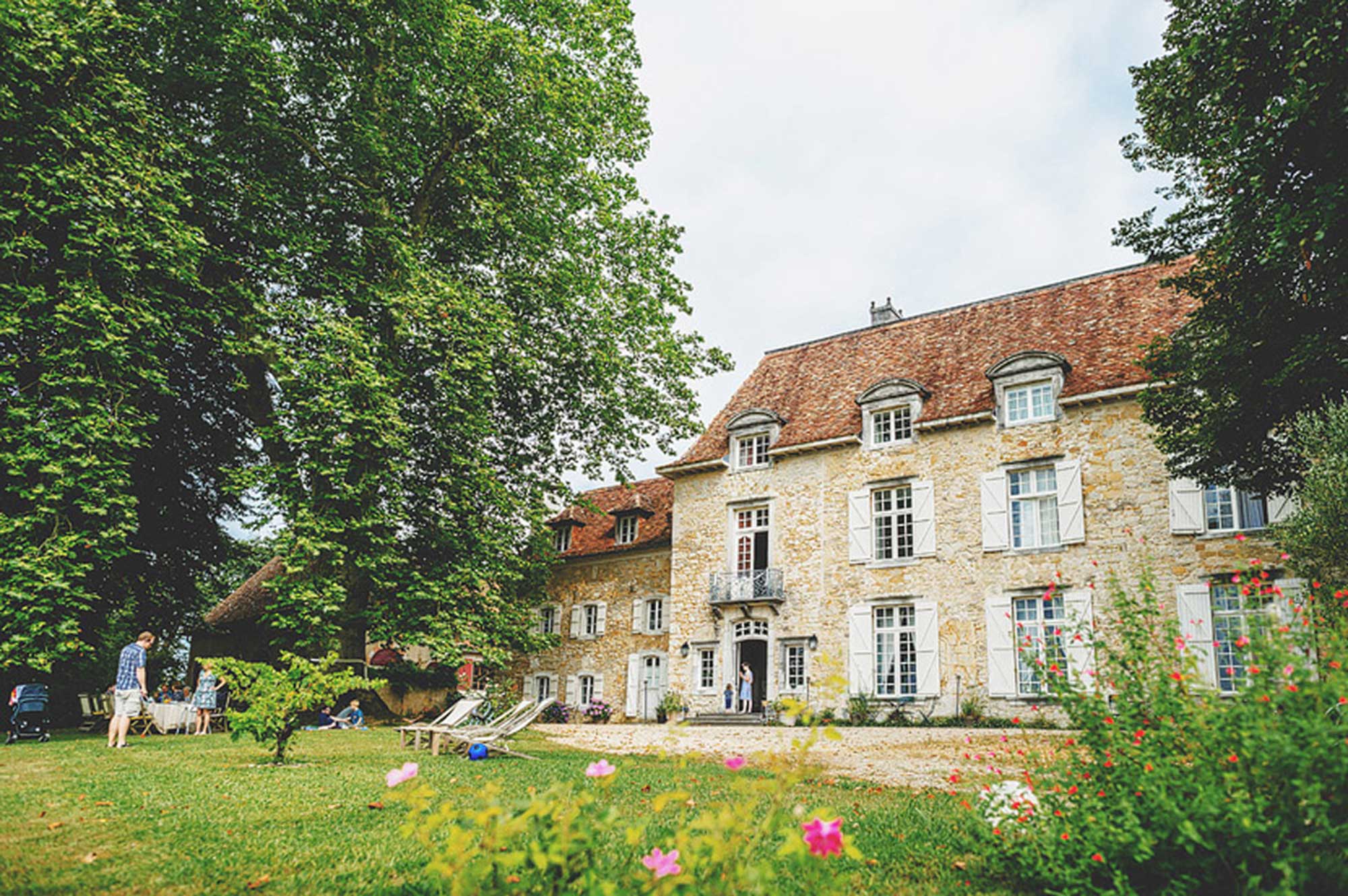 Historische Fassade des Château d'Orion mit blühendem Garten in Neu-Aquitanien