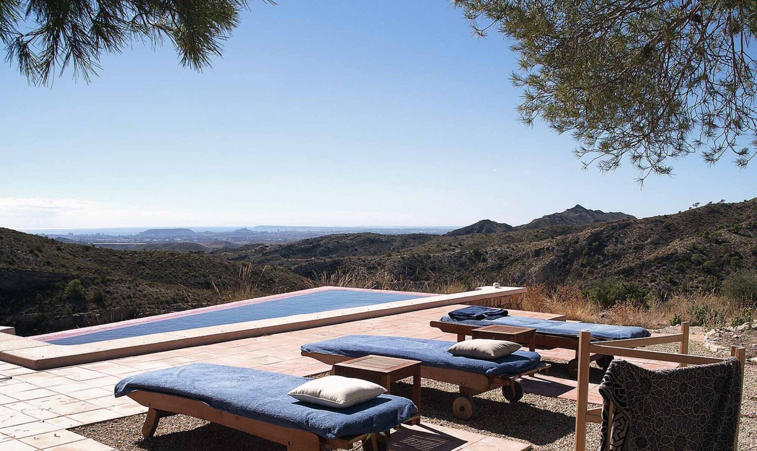 Infinity Pool mit Liegen und Blick auf Berge und Meer bei der Finca Foyeta, Costa Blanca