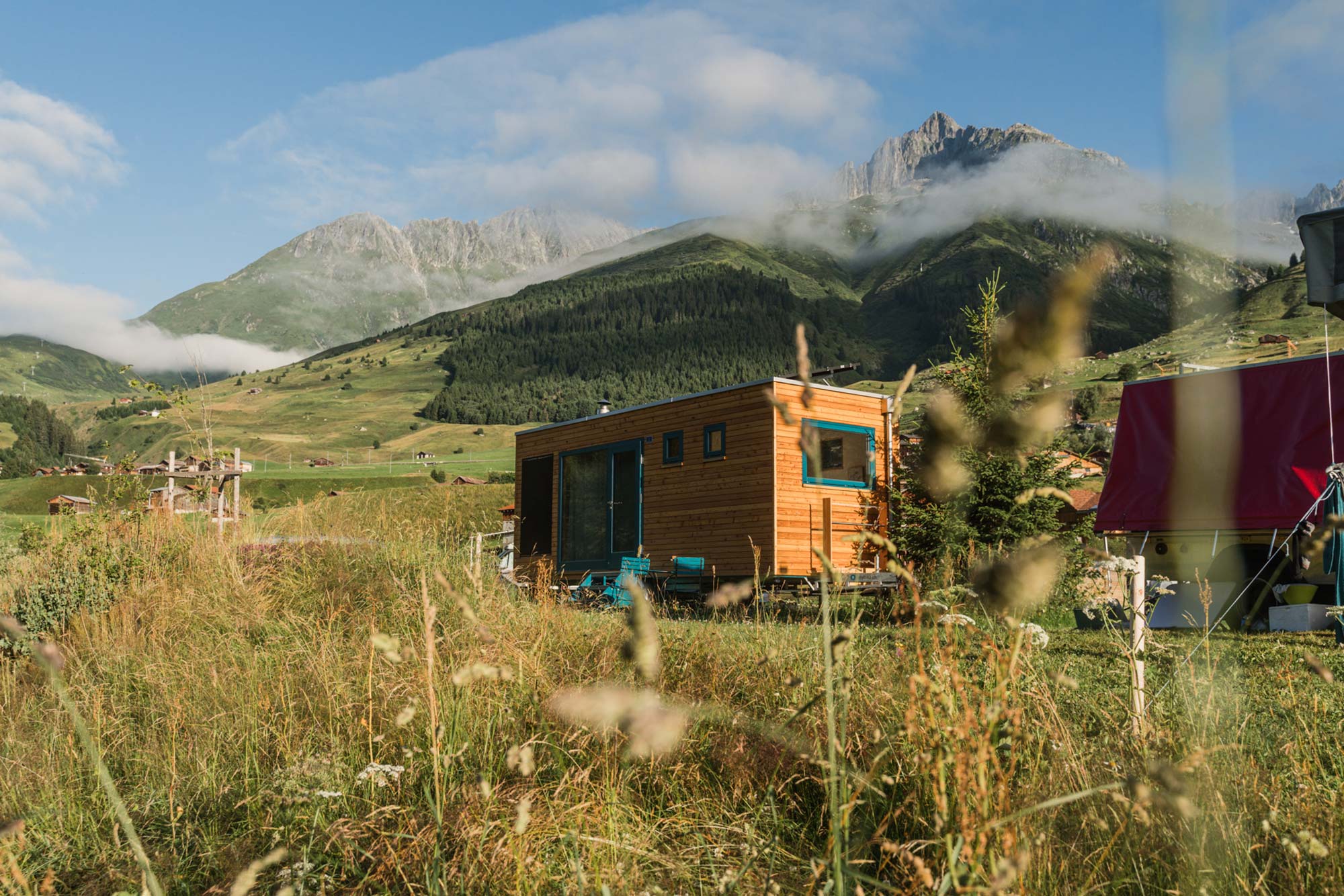 Tiny House Flurina vor schroffem Bergmassiv im Naturcamping Viva, Graubünden