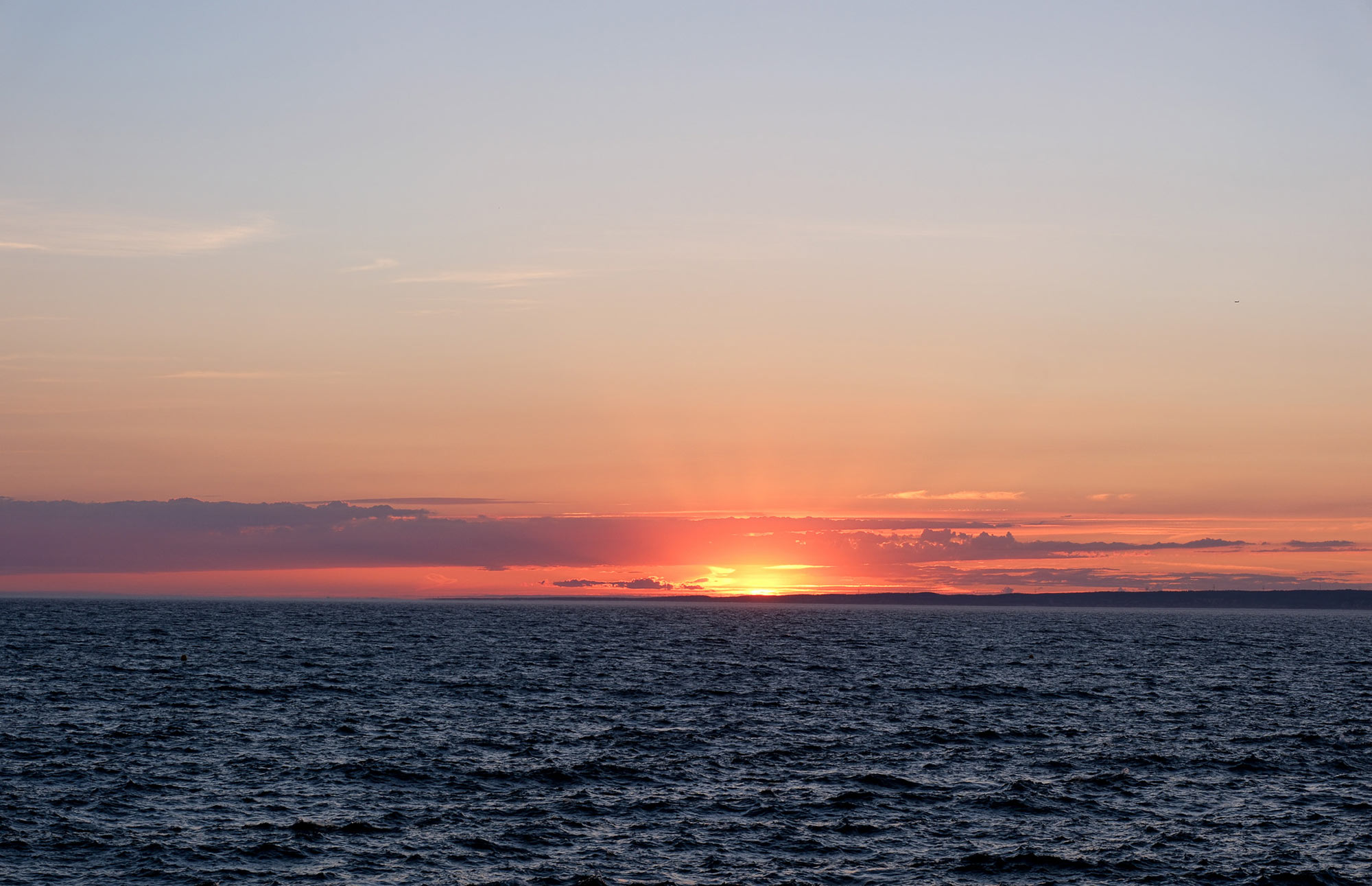 Orange leuchtender Sonnenuntergang über dem dunklen Mittelmeer vor Marseille, fotografiert während eines Segeltörns