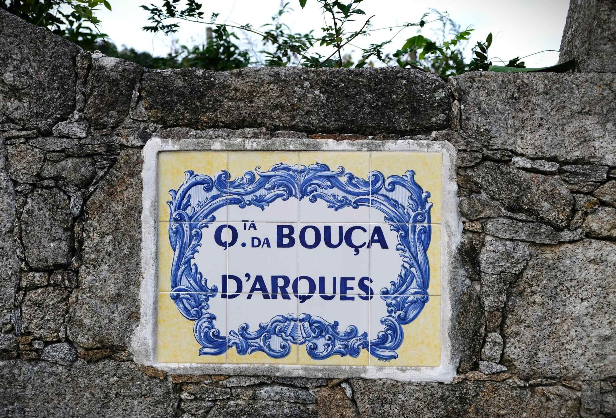 Blau-weißes Azulejo-Fliesenschild mit der Aufschrift „Quinta da Bouça d’Arques“ an einer Granitmauer