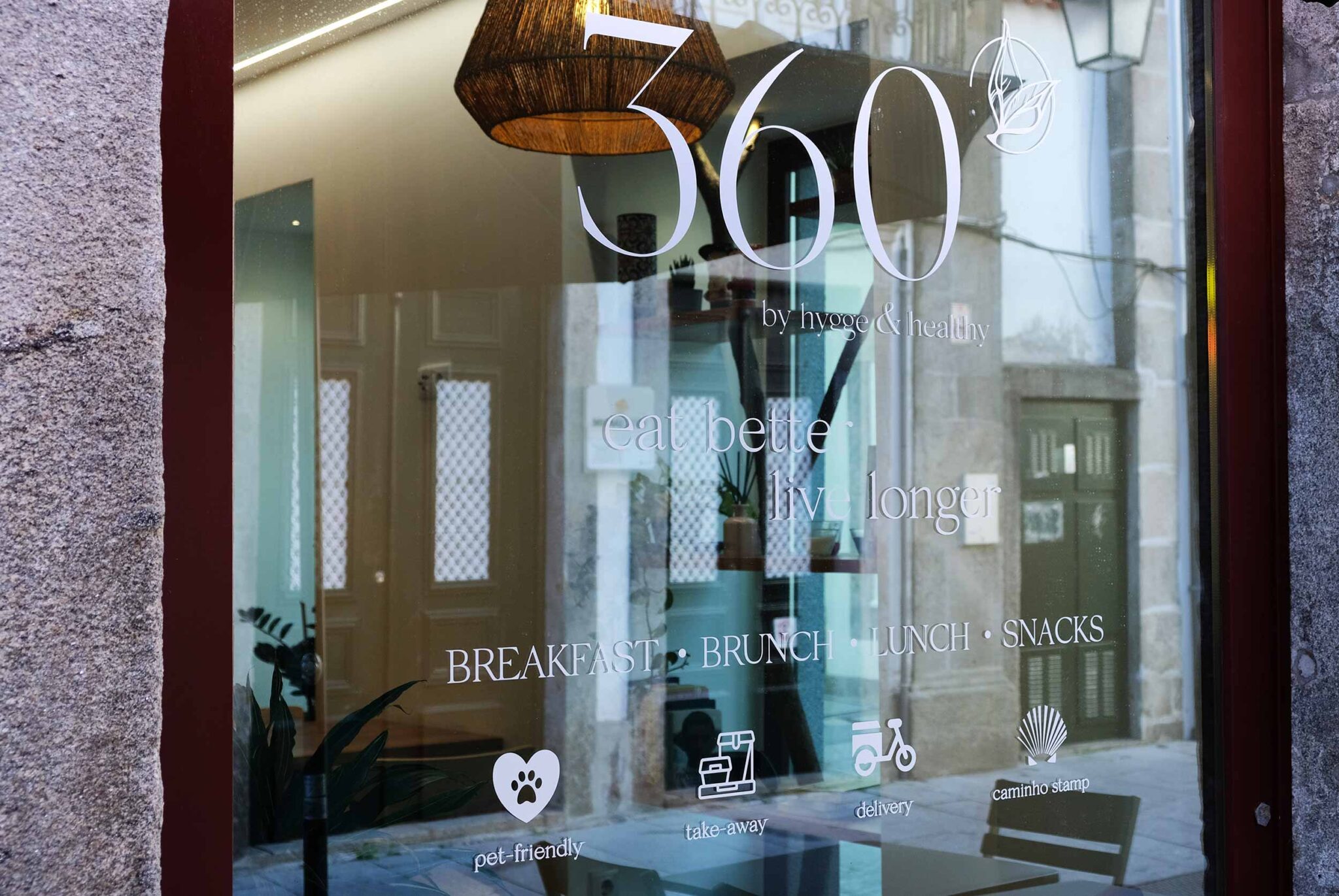 Schaufenster des Restaurants 360º by hygge&healthy in der Altstadt von Viana do Castelo mit dem Schriftzug „eat better, live longer“